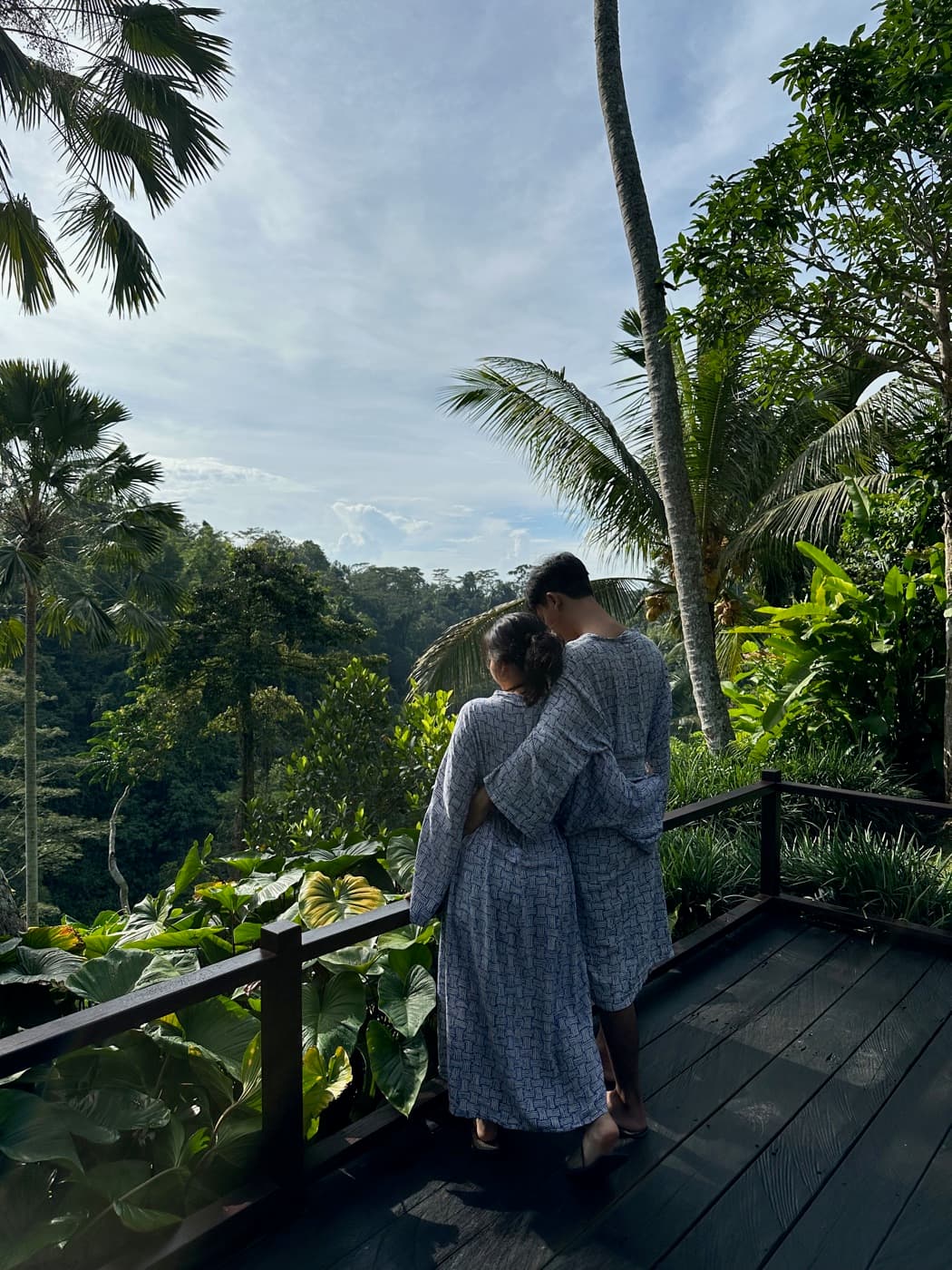 Ima and Sadu in matching robes, looking out over the Ubud valley from a wooden deck